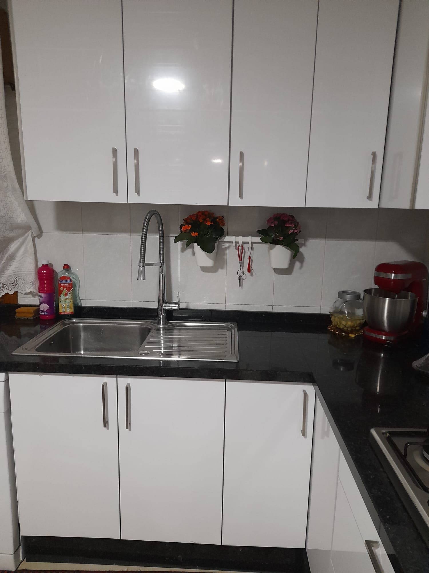 Cocina reformada con muebles blancos y encimera de granito en una vivienda de Alicante