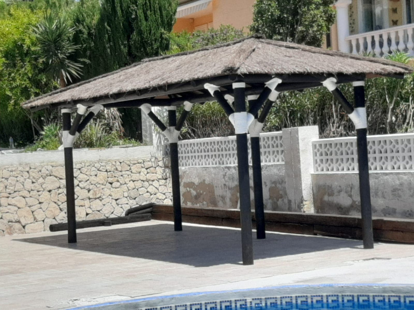 Pérgola de madera a medida junto a una piscina