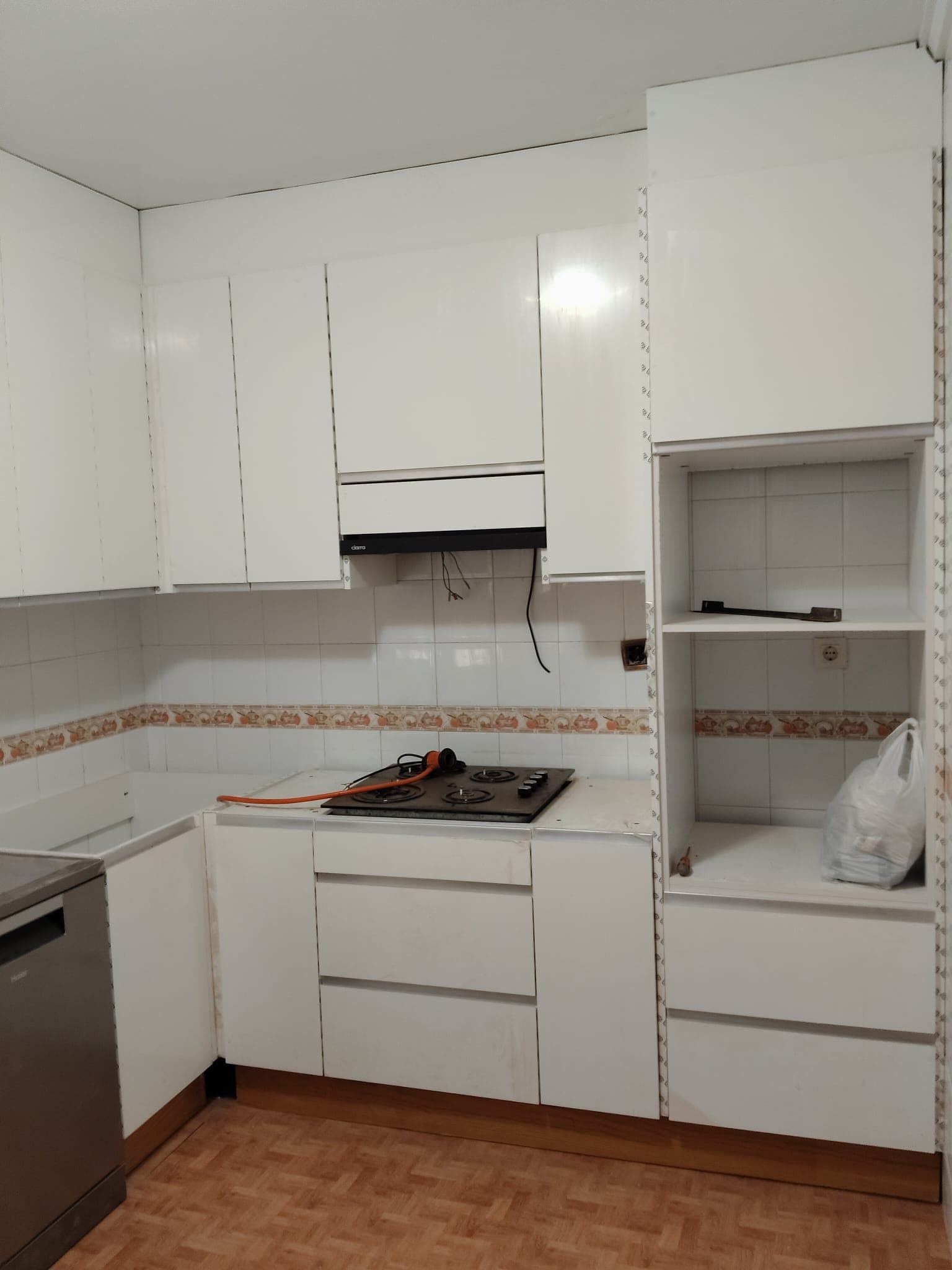 Cocina en obra con muebles blancos recién montados en Alicante